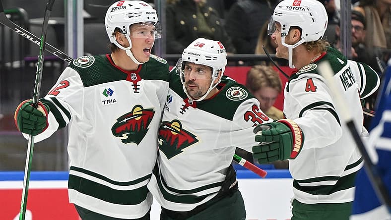 Oct 14, 2023; Toronto, Ontario, CAN; Minnesota Wild forward Matt Boldy (12) celebrates with forward Mats Zuccarello (36) and defenseman Jon Merrill (4) after scoring a goal against the Toronto Maple Leafs in the second period at Scotiabank Arena. Mandatory Credit: Dan Hamilton-USA TODAY Sports