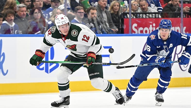 Oct 14, 2023; Toronto, Ontario, CAN; Minnesota Wild forward Matt Boldy (12) pursues the puck ahead of Toronto Maple Leafs forward Mitchell Marner (16) in the second period at Scotiabank Arena. Mandatory Credit: Dan Hamilton-USA TODAY Sports