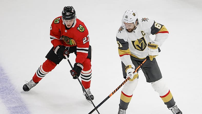 Oct 21, 2023; Chicago, Illinois, USA; Chicago Blackhawks left wing Lukas Reichel (27) battles for the puck with Vegas Golden Knights right wing Mark Stone (61) during the first period at United Center. Mandatory Credit: Kamil Krzaczynski-USA TODAY Sports