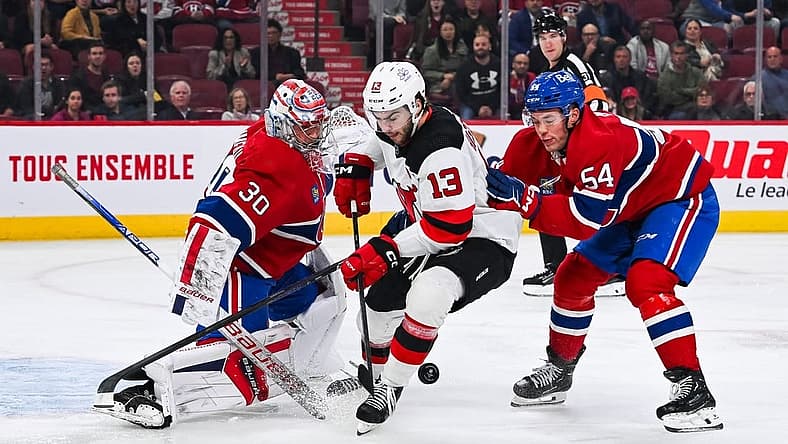 Oct 24, 2023; Montreal, Quebec, CAN; Montreal Canadiens goalie Cayden Primeau (30) makes a save against New Jersey Devils center Nico Hischier (13) with Montreal Canadiens defenseman Jordan Harris (54) help during the first period at Bell Centre. Mandatory Credit: David Kirouac-USA TODAY Sports