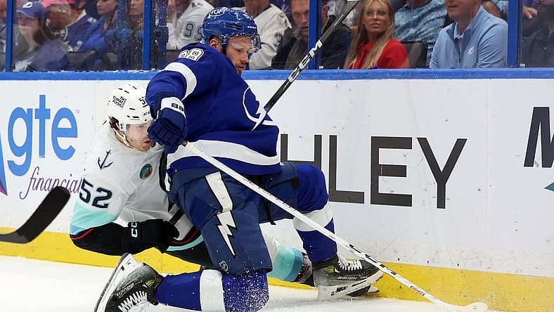 Oct 30, 2023; Tampa, Florida, USA; Seattle Kraken left wing Tye Kartye (52) and Tampa Bay Lightning defenseman Mikhail Sergachev (98) fight to control the puck during the second period at Amalie Arena. Mandatory Credit: Kim Klement Neitzel-USA TODAY Sports