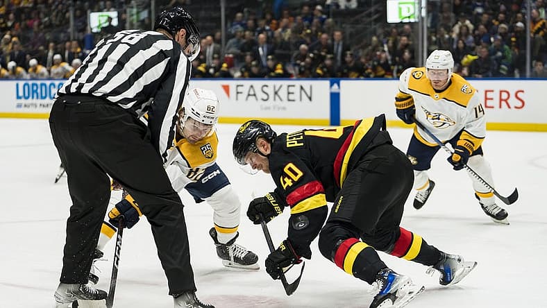 Oct 31, 2023; Vancouver, British Columbia, CAN; Vancouver Canucks forward Elias Pettersson (40) wins a face off Nashville Predators forward Tommy Novak (82) in the first period at Rogers Arena. Mandatory Credit: Bob Frid-USA TODAY Sports