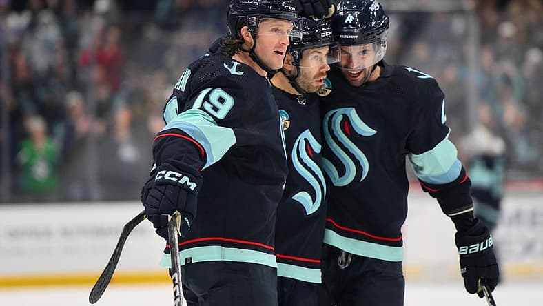 Nov 2, 2023; Seattle, Washington, USA; Seattle Kraken left wing Jared McCann (19), right wing Oliver Bjorkstrand (22) and defenseman Justin Schultz (4) celebrate after Bjorkstrand scored a goal against the Nashville Predators during the first period at Climate Pledge Arena. Mandatory Credit: Steven Bisig-USA TODAY Sports
