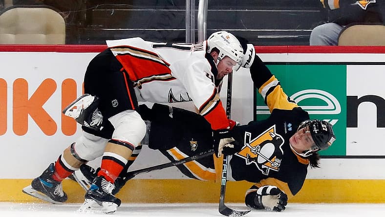 Oct 30, 2023; Pittsburgh, Pennsylvania, USA; Anaheim Ducks left wing Ross Johnston (44) checks Pittsburgh Penguins defenseman Ryan Graves (27) during the third period at PPG Paints Arena. Mandatory Credit: Charles LeClaire-USA TODAY Sports