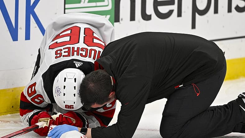 Nov 3, 2023; St. Louis, Missouri, USA; New Jersey Devils center Jack Hughes (86) is checked on by a trainer after slamming in to the boards during the first period against the St. Louis Blues at Enterprise Center. Mandatory Credit: Jeff Curry-USA TODAY Sports