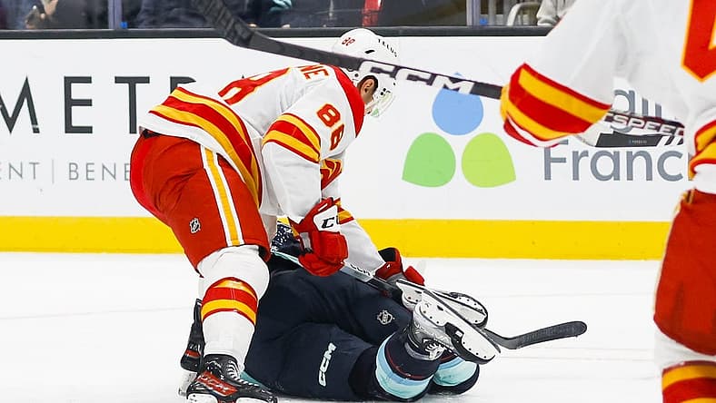 Nov 4, 2023; Seattle, Washington, USA; Calgary Flames left wing Andrew Mangiapane (88) cross-checks Seattle Kraken left wing Jared McCann (19) during the first period at Climate Pledge Arena. Mangiapane was given a major penalty for the play with intent to injure and ejected from the game. Mandatory Credit: Joe Nicholson-USA TODAY Sports