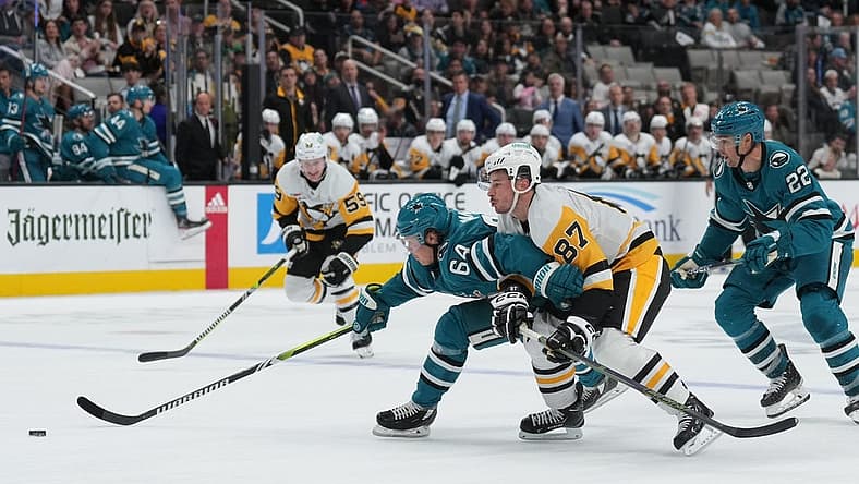 Nov 4, 2023; San Jose, California, USA; San Jose Sharks center Mikael Granlund (64) skates with the puck against Pittsburgh Penguins center Sidney Crosby (87) during the second period at SAP Center at San Jose. Mandatory Credit: Darren Yamashita-USA TODAY Sports
