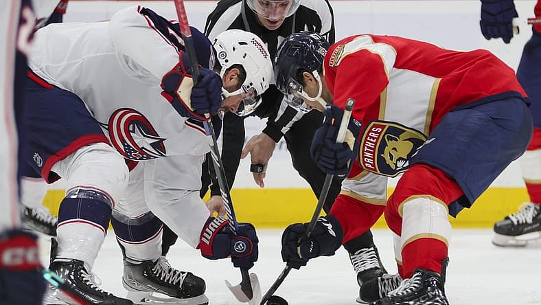 Nov 6, 2023; Sunrise, Florida, USA; Columbus Blue Jackets center Sean Kuraly (7) and Florida Panthers right wing William Lockwood (67) face-off during the second period at Amerant Bank Arena. Mandatory Credit: Sam Navarro-USA TODAY Sports