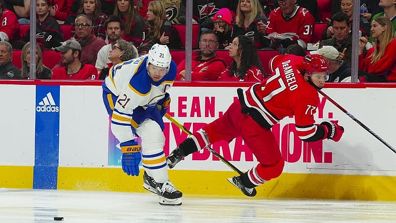 Nov 7, 2023; Raleigh, North Carolina, USA; Buffalo Sabres right wing Kyle Okposo (21) checks Carolina Hurricanes defenseman Tony DeAngelo (77) during the second period at PNC Arena. Mandatory Credit: James Guillory-USA TODAY Sports