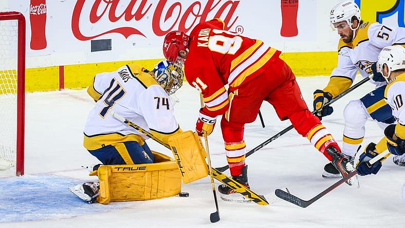 Nov 7, 2023; Calgary, Alberta, CAN; Nashville Predators goaltender Juuse Saros (74) makes a save against Calgary Flames center Nazem Kadri (91) during the first period at Scotiabank Saddledome. Mandatory Credit: Sergei Belski-USA TODAY Sports
