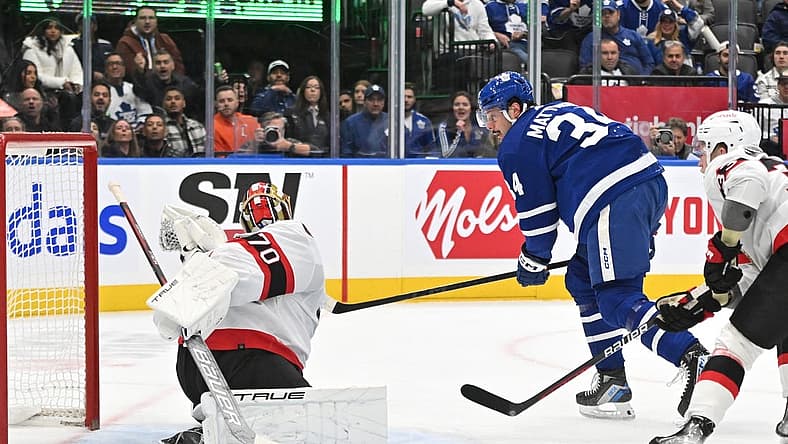 Nov 8, 2023; Toronto, Ontario, CAN; Ottawa Senators goalie Joonas Korpisalo (70) makes a glove save on Toronto Maple Leafs forward Auston Matthews (34) in the first period at Scotiabank Arena. Mandatory Credit: Dan Hamilton-USA TODAY Sports