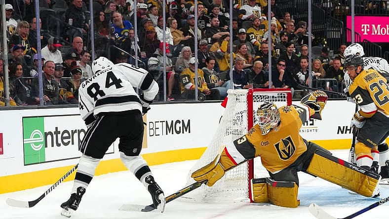 Nov 8, 2023; Las Vegas, Nevada, USA; Vegas Golden Knights goaltender Adin Hill (33) deflects the puck away from Los Angeles Kings defenseman Vladislav Gavrikov (84) during the first period at T-Mobile Arena. Mandatory Credit: Stephen R. Sylvanie-USA TODAY Sports