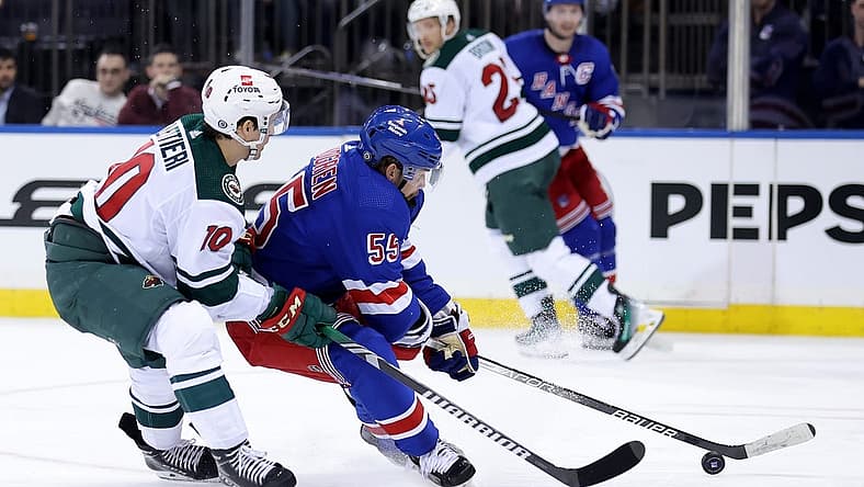 Nov 9, 2023; New York, New York, USA; New York Rangers defenseman Ryan Lindgren (55) fights for the puck against Minnesota Wild center Vinni Lettieri (10) during the second period at Madison Square Garden. Mandatory Credit: Brad Penner-USA TODAY Sports