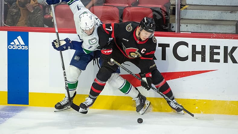 Nov 9, 2023; Ottawa, Ontario, CAN; Vancouver Canucks defenseman Carson Soucy (7) and Ottawa Senators left wing Brady Tkachuk (7) battle for the puck in the third period at the Canadian Tire Centre. Mandatory Credit: Marc DesRosiers-USA TODAY Sports