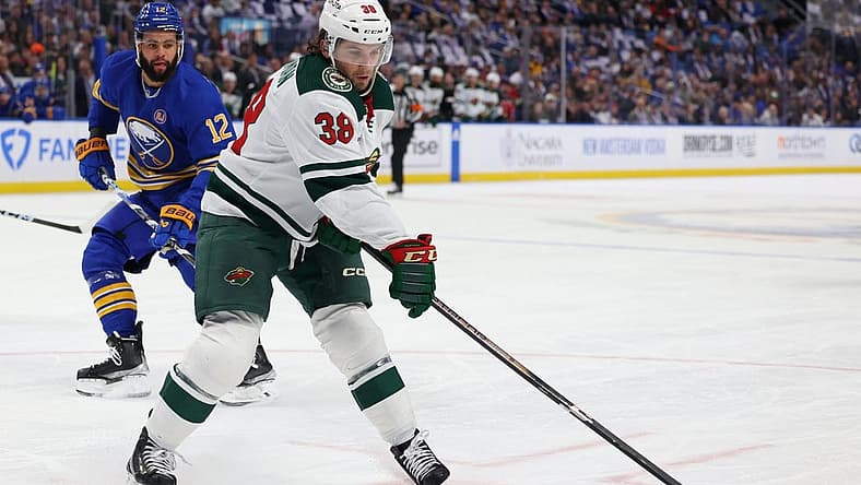 Nov 10, 2023; Buffalo, New York, USA; Buffalo Sabres left wing Jordan Greenway (12) watches as Minnesota Wild right wing Ryan Hartman (38) drops a pass during the first period at KeyBank Center. Mandatory Credit: Timothy T. Ludwig-USA TODAY Sports