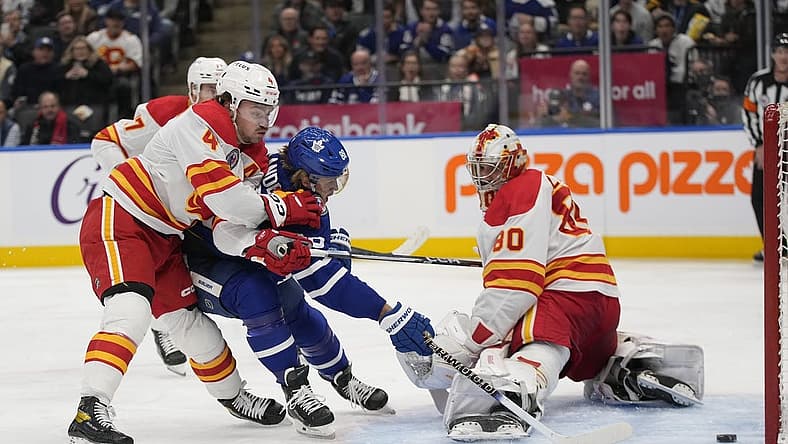Nov 10, 2023; Toronto, Ontario, CAN; Toronto Maple Leafs forward William Nylander (88) scores against Calgary Flames goaltender Dan Vladar (80) and defenseman Rasmus Andersson (4) during the first period at Scotiabank Arena. Mandatory Credit: John E. Sokolowski-USA TODAY Sports
