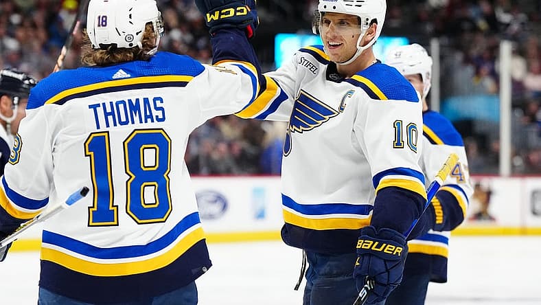 Nov 11, 2023; Denver, Colorado, USA; St. Louis Blues center Brayden Schenn (10) celebrates his hat trick goal with center Robert Thomas (18) in the third period against the Colorado Avalanche at Ball Arena. Mandatory Credit: Ron Chenoy-USA TODAY Sports