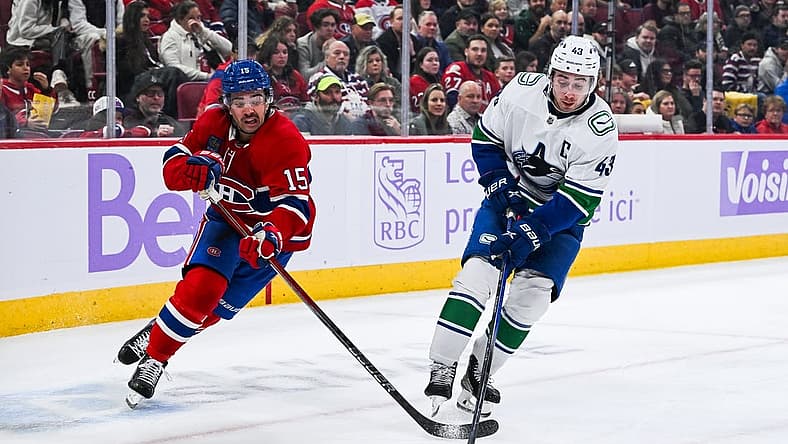 Nov 12, 2023; Montreal, Quebec, CAN; Vancouver Canucks defenseman Quinn Hughes (43) defends the puck against Montreal Canadiens center Alex Newhook (15) during the second period at Bell Centre. Mandatory Credit: David Kirouac-USA TODAY Sports