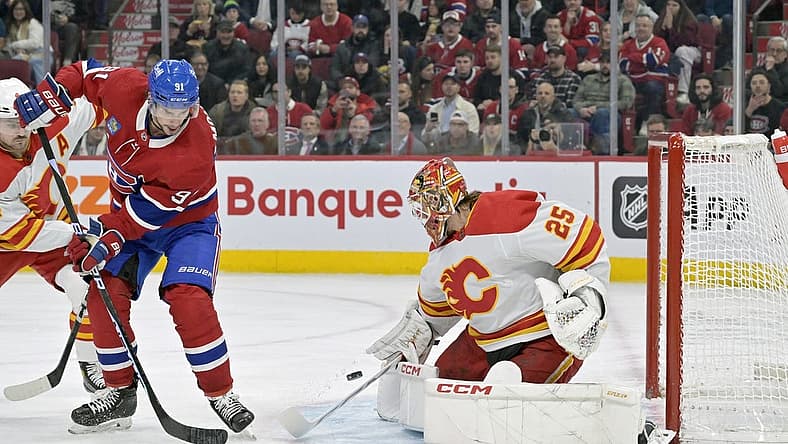 Nov 14, 2023; Montreal, Quebec, CAN; Calgary Flames goalie Jacob Markstrom (25) stops Montreal Canadiens forward Sean Monahan (91) during the first period at the Bell Centre. Mandatory Credit: Eric Bolte-USA TODAY Sports