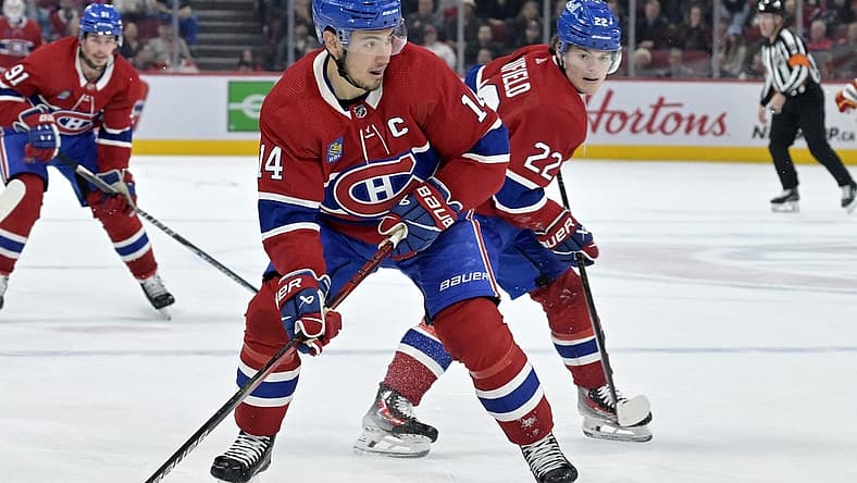 Nov 14, 2023; Montreal, Quebec, CAN; Montreal Canadiens forward Nick Suzuki (14) brings the puck in the Calgary Flames zone with the help of teammate forward Cole Caufield (22) during the third period at the Bell Centre. Mandatory Credit: Eric Bolte-USA TODAY Sports