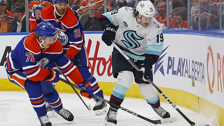 Nov 15, 2023; Edmonton, Alberta, CAN; Seattle Kraken forward Jared McCann (19) and Edmonton Oilers forward Ryan McLeod (71) battle along the boards for a loose puck during the second period at Rogers Place. Mandatory Credit: Perry Nelson-USA TODAY Sports