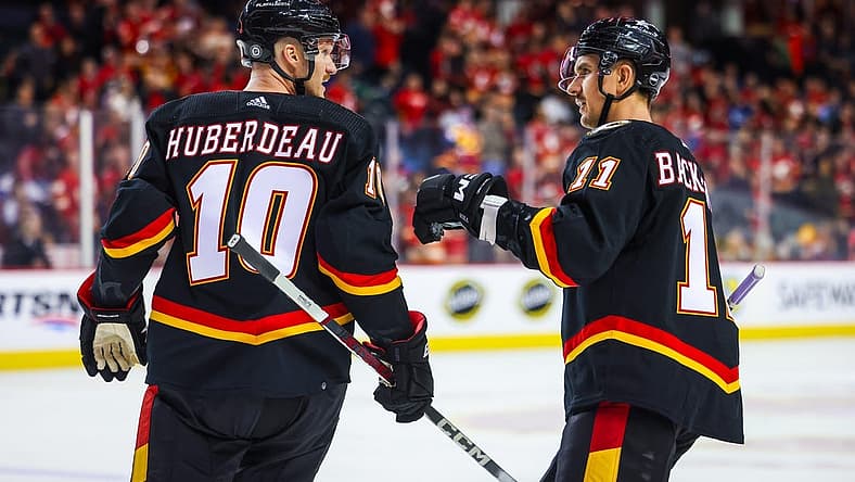 Nov 16, 2023; Calgary, Alberta, CAN; Calgary Flames center Jonathan Huberdeau (10) celebrates his goal with center Mikael Backlund (11) during the third period against the Vancouver Canucks at Scotiabank Saddledome. Mandatory Credit: Sergei Belski-USA TODAY Sports