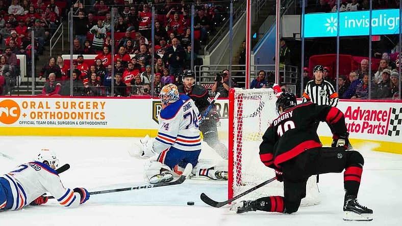 Nov 22, 2023; Raleigh, North Carolina, USA; Carolina Hurricanes center Jack Drury (18) scores a goal past Edmonton Oilers goaltender Stuart Skinner (74) during the first period at PNC Arena. Mandatory Credit: James Guillory-USA TODAY Sports