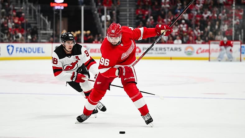 Nov 22, 2023; Detroit, Michigan, USA; Detroit Red Wings defenseman Jake Walman (96) shoots as New Jersey New Jersey Devils center Jack Hughes (86) attempts to defend during the second period at Little Caesars Arena. Mandatory Credit: Tim Fuller-USA TODAY Sports