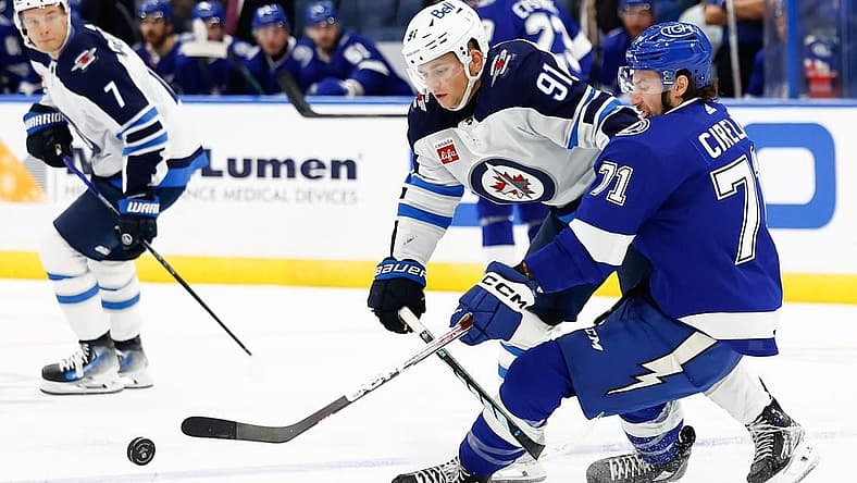 Nov 22, 2023; Tampa, Florida, USA; Winnipeg Jets center Cole Perfetti (91) and Tampa Bay Lightning center Anthony Cirelli (71) fight for the puck during the second period at Amalie Arena. Mandatory Credit: Douglas DeFelice-USA TODAY Sports