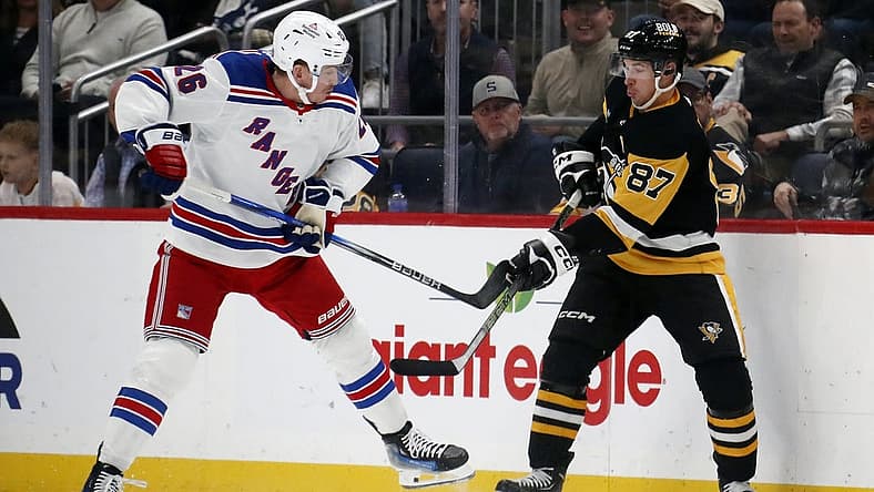 Nov 22, 2023; Pittsburgh, Pennsylvania, USA; New York Rangers left wing Jimmy Vesey (26) and Pittsburgh Penguins center Sidney Crosby (87) battle for the puck during the second period at PPG Paints Arena. Mandatory Credit: Charles LeClaire-USA TODAY Sports