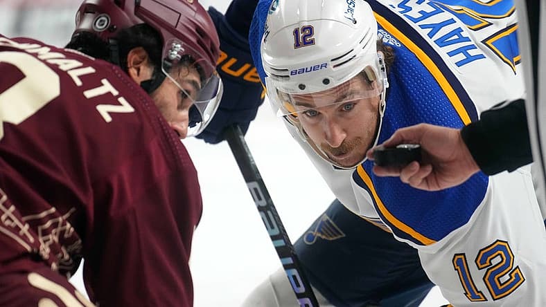 Nov 22, 2023; Tempe, Arizona, USA; St. Louis Blues right wing Kevin Hayes (12) lines up for a face off against Arizona Coyotes center Nick Schmaltz (8) during the second period at Mullett Arena. Mandatory Credit: Joe Camporeale-USA TODAY Sports