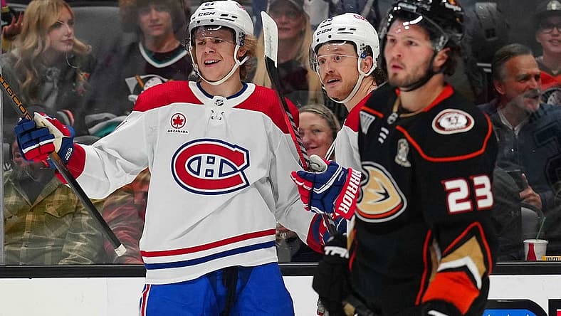 Nov 22, 2023; Anaheim, California, USA; Montreal Canadiens defenseman Kaiden Guhle (21) and left wing Michael Pezzetta (55) celebrate after a goal as Anaheim Ducks center Mason McTavish (23) reacts in the first period at Honda Center. Mandatory Credit: Kirby Lee-USA TODAY Sports