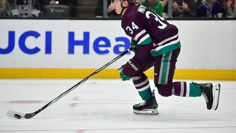 Nov 24, 2023; Anaheim, California, USA; Anaheim Ducks defenseman Pavel Mintyukov (34) moves the puck against the Los Angeles Kings during the third period at Honda Center. Mandatory Credit: Gary A. Vasquez-USA TODAY Sports