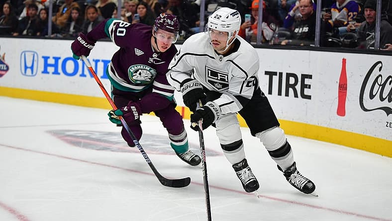 Nov 24, 2023; Anaheim, California, USA; Los Angeles Kings left wing Kevin Fiala (22) moves the puck ahead of Anaheim Ducks defenseman Jackson LaCombe (60) during the third period at Honda Center. Mandatory Credit: Gary A. Vasquez-USA TODAY Sports