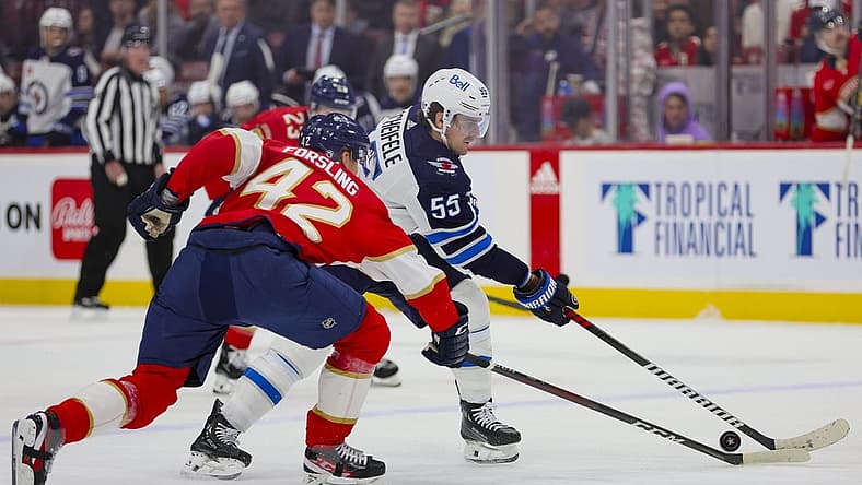 Nov 24, 2023; Sunrise, Florida, USA; Winnipeg Jets center Mark Scheifele (55) moves the puck against Florida Panthers defenseman Gustav Forsling (42) during the first period at Amerant Bank Arena. Mandatory Credit: Sam Navarro-USA TODAY Sports