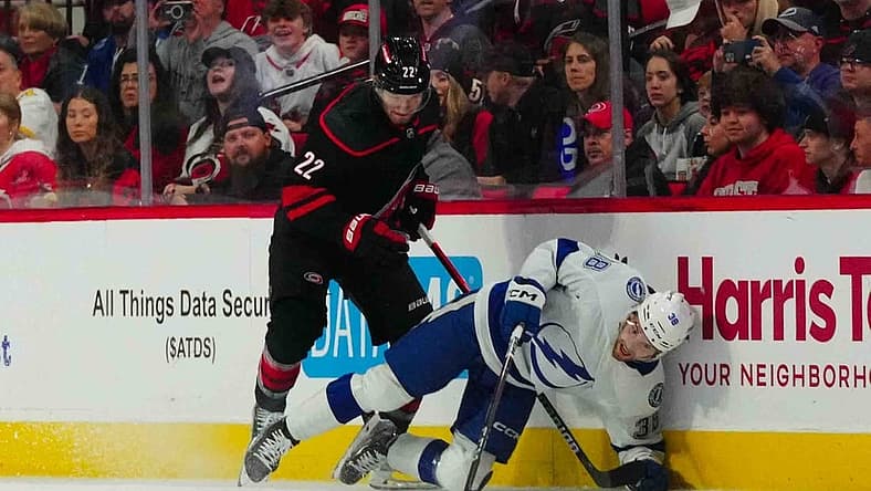 Nov 24, 2023; Raleigh, North Carolina, USA; Carolina Hurricanes defenseman Brett Pesce (22) checks Tampa Bay Lightning left wing Brandon Hagel (38) during the first period at PNC Arena. Mandatory Credit: James Guillory-USA TODAY Sports