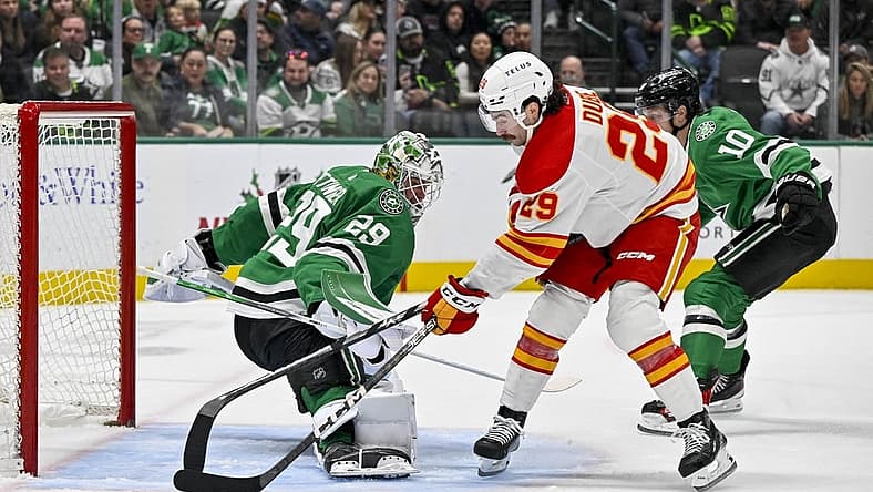Nov 24, 2023; Dallas, Texas, USA; Dallas Stars goaltender Jake Oettinger (29) turns aside a shot by Calgary Flames center Dillon Dube (29) during the first period at the American Airlines Center. Mandatory Credit: Jerome Miron-USA TODAY Sports