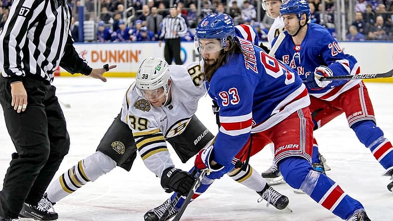 Nov 25, 2023; New York, New York, USA; Boston Bruins center Morgan Geekie (39) and New York Rangers center Mika Zibanejad (93) battle for the puck after a face-off during the first period at Madison Square Garden. Mandatory Credit: Danny Wild-USA TODAY Sports
