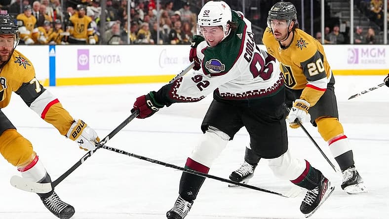 Nov 25, 2023; Las Vegas, Nevada, USA; Arizona Coyotes center Logan Cooley (92) shoots the puck against the Vegas Golden Knights during the second period at T-Mobile Arena. Mandatory Credit: Stephen R. Sylvanie-USA TODAY Sports