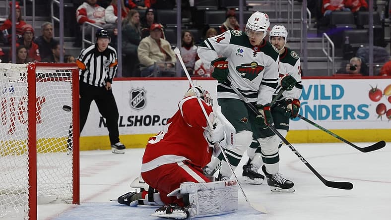 Nov 26, 2023; Detroit, Michigan, USA; Minnesota Wild center Joel Eriksson Ek (14) scores a goal on Detroit Red Wings goaltender Alex Lyon (34) in the first period at Little Caesars Arena. Mandatory Credit: Rick Osentoski-USA TODAY Sports