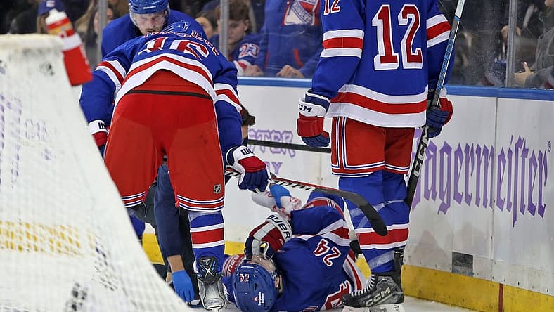 Nov 27, 2023; New York, New York, USA; New York Rangers right wing Kaapo Kakko (24) is helped by a trainer on the ice after an injury to his left leg during the second period against the Buffalo Sabres at Madison Square Garden. Mandatory Credit: Danny Wild-USA TODAY Sports
