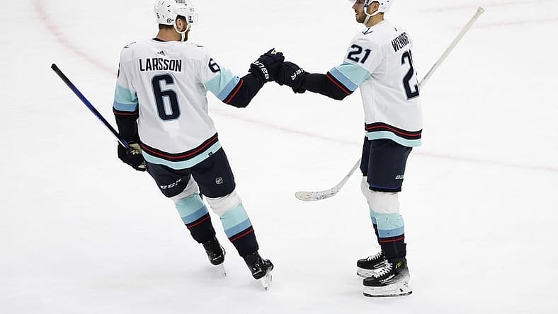 Nov 28, 2023; Chicago, Illinois, USA; Seattle Kraken center Alex Wennberg (21) celebrates with defenseman Adam Larsson (6) after scoring against the Chicago Blackhawks during the first period at United Center. Mandatory Credit: Kamil Krzaczynski-USA TODAY Sports