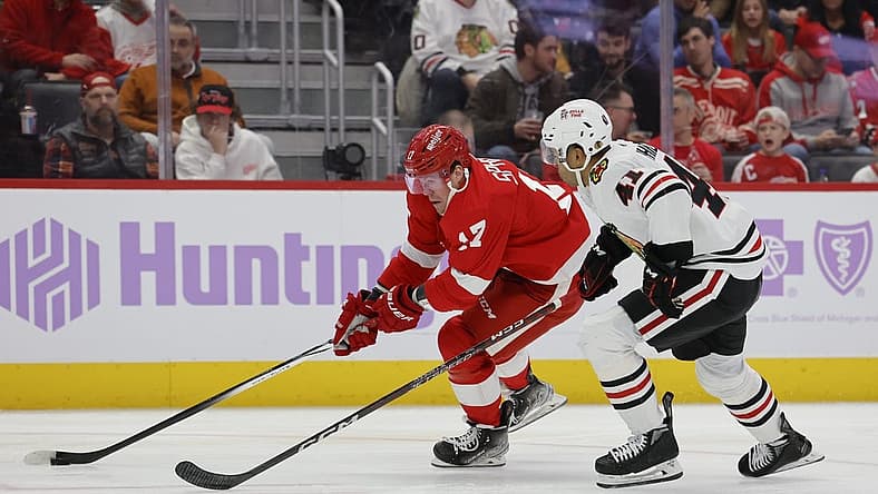 Nov 30, 2023; Detroit, Michigan, USA; Detroit Pistons guard Stanley Umude (17) skates with the puck defended by Chicago Blackhawks defenseman Isaak Phillips (41) in the second period at Little Caesars Arena. Mandatory Credit: Rick Osentoski-USA TODAY Sports