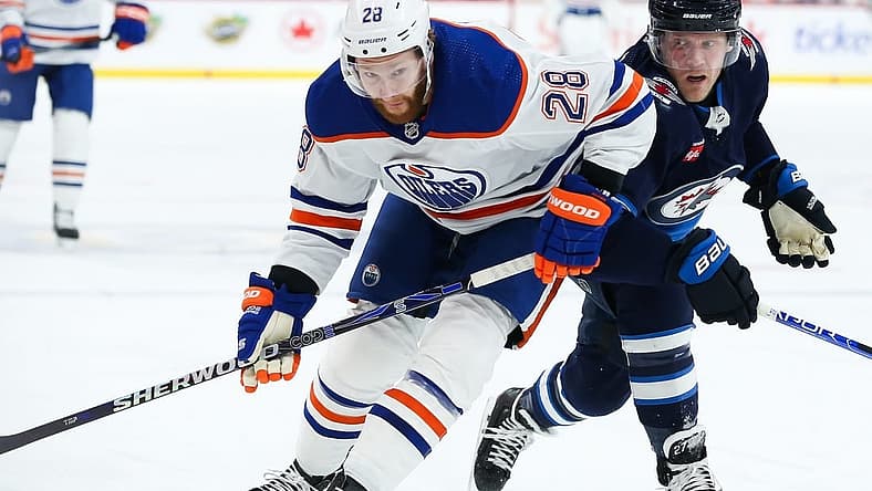 Nov 30, 2023; Winnipeg, Manitoba, CAN; Edmonton Oilers forward Connor Brown (28) jostles for position with Winnipeg Jets forward Nikolaj Ehlers (27) during the first period at Canada Life Centre. Mandatory Credit: Terrence Lee-USA TODAY Sports