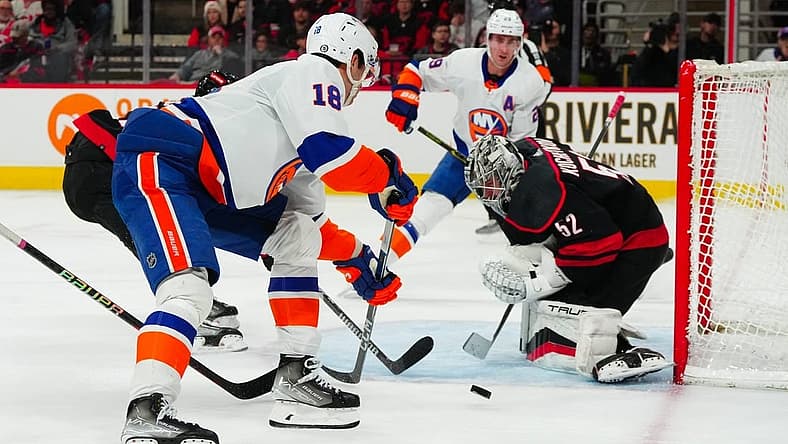Nov 30, 2023; Raleigh, North Carolina, USA; Carolina Hurricanes goaltender Pyotr Kochetkov (52) stops the scoring attempt by New York Islanders left wing Pierre Engvall (18) during the second period at PNC Arena. Mandatory Credit: James Guillory-USA TODAY Sports