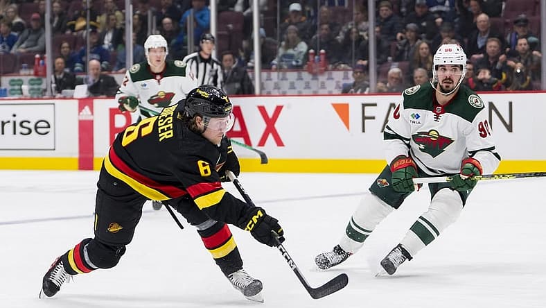 Mar 2, 2023; Vancouver, British Columbia, CAN; Minnesota Wild forward Marcus Johansson (90) watches as Vancouver Canucks forward Brock Boeser (6) shoots in the third period at Rogers Arena. Wild won 2-1. Mandatory Credit: Bob Frid-USA TODAY Sports