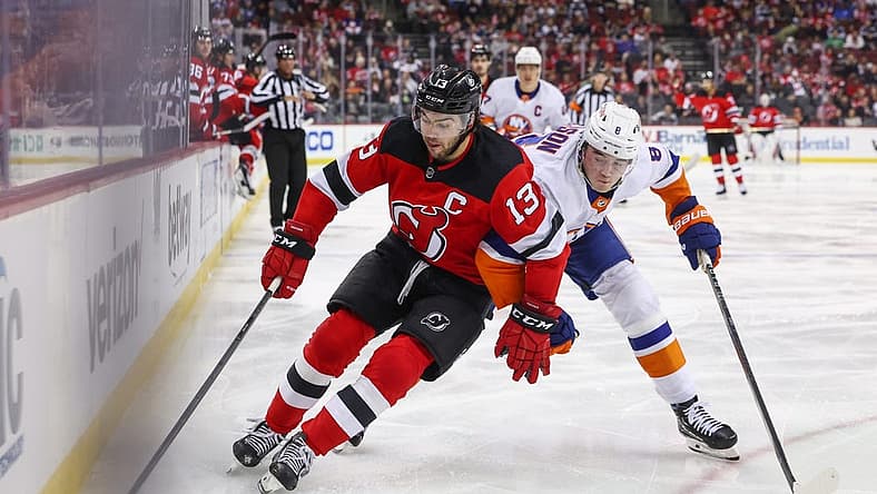 Nov 28, 2023; Newark, New Jersey, USA; New Jersey Devils center Nico Hischier (13) skates with the puck while being defended by New York Islanders defenseman Noah Dobson (8) during the second period at Prudential Center. Mandatory Credit: Ed Mulholland-USA TODAY Sports