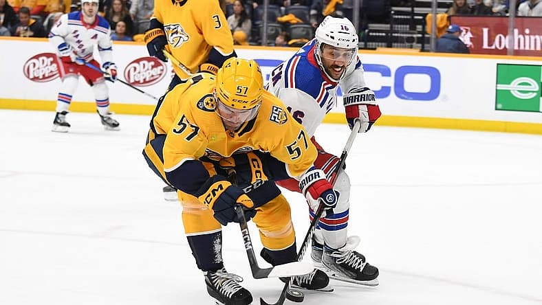 Dec 2, 2023; Nashville, Tennessee, USA; Nashville Predators defenseman Dante Fabbro (57) plays the puck away from New York Rangers center Vincent Trocheck (16) during the second period at Bridgestone Arena. Mandatory Credit: Christopher Hanewinckel-USA TODAY Sports