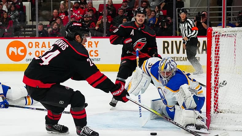 Dec 2, 2023; Raleigh, North Carolina, USA; Carolina Hurricanes center Sebastian Aho (20) sends the past to center Seth Jarvis (24) past Buffalo Sabres goaltender Eric Comrie (31) during the first period at PNC Arena. Mandatory Credit: James Guillory-USA TODAY Sports
