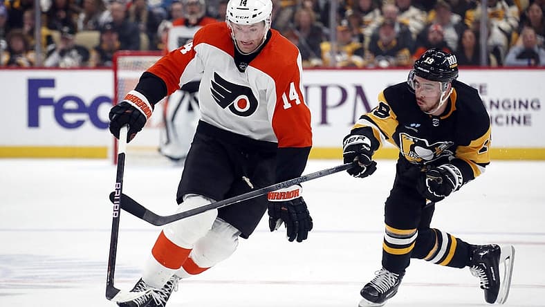 Dec 2, 2023; Pittsburgh, Pennsylvania, USA; Philadelphia Flyers center Sean Couturier (14) moves the puck up ice pat Pittsburgh Penguins right wing Reilly Smith (19) during the second period at PPG Paints Arena. Mandatory Credit: Charles LeClaire-USA TODAY Sports